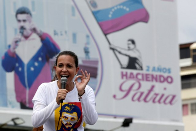 Venezuelan opposition leader Maria Corina Machado speaks in front of a billboard with a picture of Venezuela's President Nicolas Maduro during a rally against him in Caracas, Venezuela April 24, 2017. The billboard reads, "2 years making homeland". REUTERS/Marco Bello