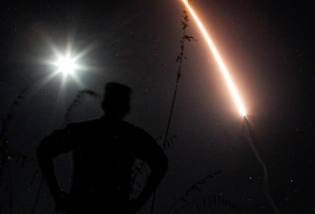 Photographers take pictures of a streak of light trailing off into the night sky as the US military test fires an unarmed intercontinental ballistic missile (ICBM) at Vandenberg Air Force Base, some 130 miles (209 kms) northwest of Los Angeles, California early on May 3, 2017. / AFP PHOTO / RINGO CHIU