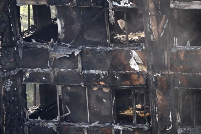 The remains of Grenfell Tower, a residential tower block in west London which was gutted by fire on June 15, 2017. Firefighters searched for bodies today in a London tower block gutted by a blaze that has already left 12 dead, as questions grew over whether a recent refurbishment contributed to the fire. / AFP PHOTO / Tolga AKMEN
