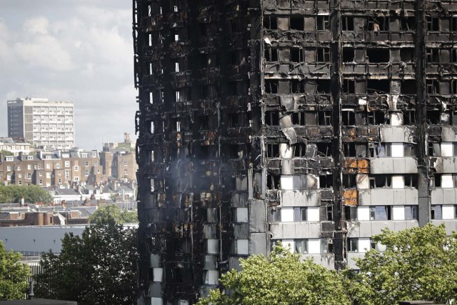 The remains of residential tower block Grenfell Tower are pictured, in west London on June 15, 2017, a day after it was gutted by fire. Firefighters searched for bodies today in a London tower block gutted by a blaze that has already left 12 dead, as questions grew over whether a recent refurbishment contributed to the fire. / AFP PHOTO / Tolga AKMEN