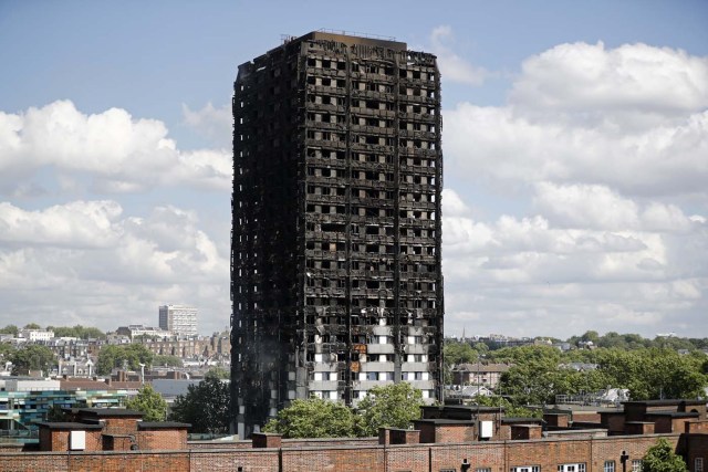 The remains of residential tower block Grenfell Tower are pictured, in west London on June 15, 2017, a day after it was gutted by fire. Firefighters searched for bodies today in a London tower block gutted by a blaze that has already left 12 dead, as questions grew over whether a recent refurbishment contributed to the fire. / AFP PHOTO / Tolga AKMEN
