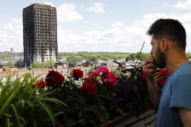 The remains of residential tower block Grenfell Tower are seen from Dixon House a nearby tower block, in west London on June 15, 2017, a day after it was gutted by fire. Firefighters searched for bodies today in a London tower block gutted by a blaze that has already left 12 dead, as questions grew over whether a recent refurbishment contributed to the fire. / AFP PHOTO / Tolga AKMEN