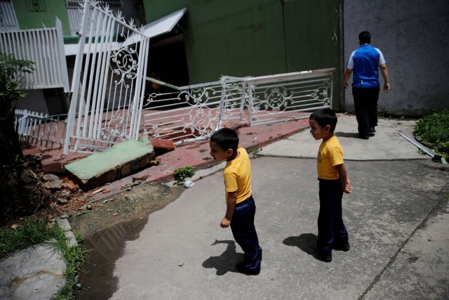 Children stand near the broken fencing of a building after opposition supporters and security forces clashed in and outside the building on Tuesday according to residents, in Caracas, Venezuela June 14, 2017. REUTERS/Ivan Alvarado