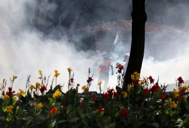 Volunteer members of a primary care response team run from tear gas during a rally against Venezuela's President Nicolas Maduro's government in Caracas, Venezuela June 14, 2017. REUTERS/Carlos Garcia Rawlins