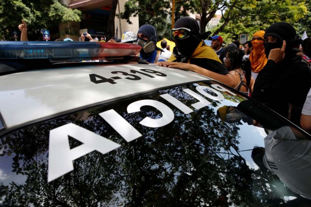 Demonstrators surround a patrol vehicle, during a rally against Venezuela's President Nicolas Maduro's government in Caracas, Venezuela June 27, 2017. REUTERS/Ivan Alvarado