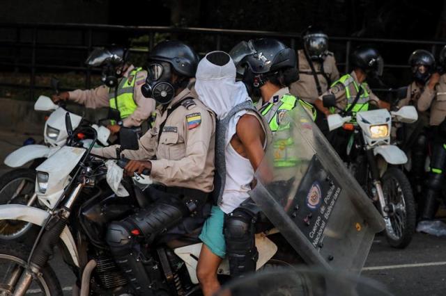 Reporteros gráficos denuncian que los cuerpos de seguridad están cubriendo los rostros de los manifestantes detenidos. Foto: EFE