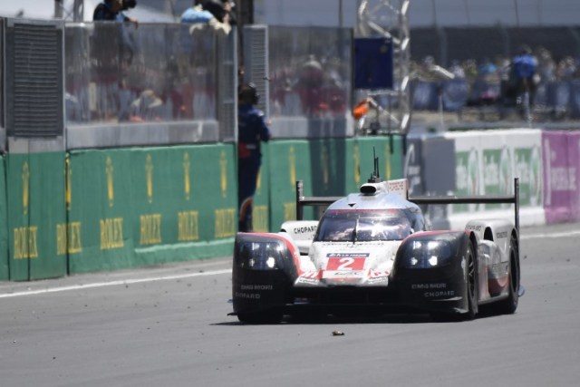 German's driver Timo Bernhard crosses the finish line on his Porsche 919 Hybrid N°2 during the Le Mans 24 hours endurance race, on June 18, 2017 in Le Mans. Timo Bernhard steered Porsche to a 19th Le Mans title in a gripping 85th edition of the 24 Hour endurance classic on Sunday. / AFP PHOTO / DAMIEN MEYER