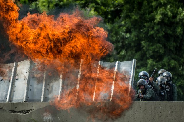 El estallido de una bomba molotov lanzada contra oficiales de la Fuerza Armada Nacional Bolivariana que disparaban gases lacrimógenos y perdigones durante una manifestación en Caracas. Credit Meridith Kohut para The New York Times