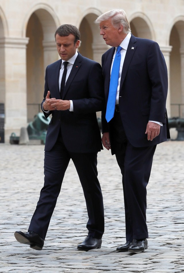 French President Emmanuel Macron and U.S. President Donald Trump walk in the courtyard as they leave after a welcoming ceremony at the Invalides in Paris, France, July 13, 2017. REUTERS/Yves Herman