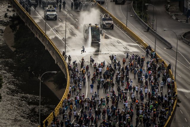 Una tanqueta usó su cañón de agua contra los manifestantes en la autopista Francisco Fajardo, en mayo. Credit Meridith Kohut para The New York Times