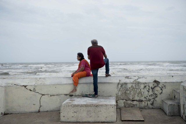 People look out from a seawall to the Gulf of Mexico as the effects of Hurricane Harvey are seen August 26, 2017 in Galveston, Texas. Hurricane Harvey left a deadly trail of devastation Saturday in Texas, as officials warned of "catastrophic" flooding and said that recovering from the most powerful storm to hit the United States in more than a decade could take years. / AFP PHOTO / Brendan Smialowski / ?The erroneous mention[s] appearing in the metadata of this photo by Brendan Smialowski has been modified in AFP systems in the following manner: [Hurricane Harvey] instead of [Hurricane Henry]. Please immediately remove the erroneous mention[s] from all your online services and delete it from your servers. If you have been authorized by AFP to distribute it to third parties, please ensure that the same actions are carried out by them. Failure to promptly comply with these instructions will entail liability on your part for any continued or post notification usage. Therefore we thank you very much for all your attention and prompt action. We are sorry for the inconvenience this notification may cause and remain at your disposal for any further information you may require.?