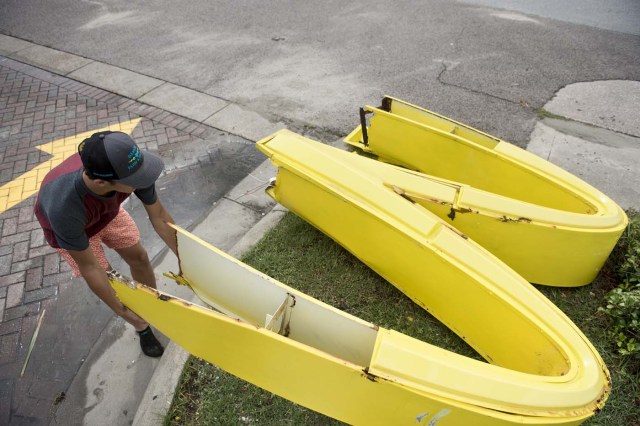 A passerby tries to pickup a fallen McDonalds logo as the effects of Hurricane Harvey are seen August 26, 2017 in Galveston, Texas. Hurricane Harvey left a deadly trail of devastation Saturday in Texas, as officials warned of "catastrophic" flooding and said that recovering from the most powerful storm to hit the United States in more than a decade could take years. / AFP PHOTO / Brendan Smialowski / ?The erroneous mention[s] appearing in the metadata of this photo by Brendan Smialowski has been modified in AFP systems in the following manner: [Hurricane Harvey] instead of [Hurricane Henry]. Please immediately remove the erroneous mention[s] from all your online services and delete it from your servers. If you have been authorized by AFP to distribute it to third parties, please ensure that the same actions are carried out by them. Failure to promptly comply with these instructions will entail liability on your part for any continued or post notification usage. Therefore we thank you very much for all your attention and prompt action. We are sorry for the inconvenience this notification may cause and remain at your disposal for any further information you may require.?