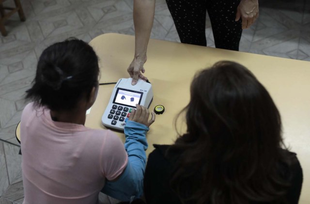 A person places their thumb on an identification machine at a polling station during the Constituent Assembly election in Caracas, Venezuela, July 30, 2017. REUTERS/Marco Bello