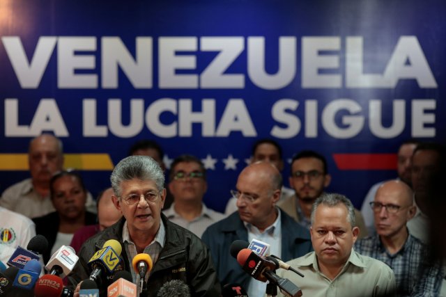 Henry Ramos Allup, lawmaker of the Venezuelan coalition of opposition parties (MUD), talks to the media during a news conference in Caracas, Venezuela August 17, 2017. The billboard in the back reads "Venezuela the fight goes on". REUTERS/Marco Bello