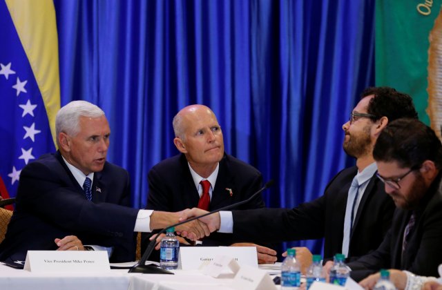 U.S. Vice President Mike Pence shakes hands with former prisoner Francisco Marquez after hearing his story as meets with members of the Venezuelan exile community, recent Venezuelan migrants, other local leaders and officials about the continuing devastation and unrest in Venezuela at Our Lady of Guadalupe Catholic Church in Doral, Florida, August 23, 2017. Florida Gov. Rick Scott is in center. REUTERS/Joe Skipper