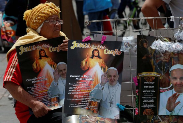 A woman sells posters with images of Pope Francis outside at the Cathedral of Bogota in Bolivar Square, Colombia September 3, 2017. REUTERS/Henry Romero