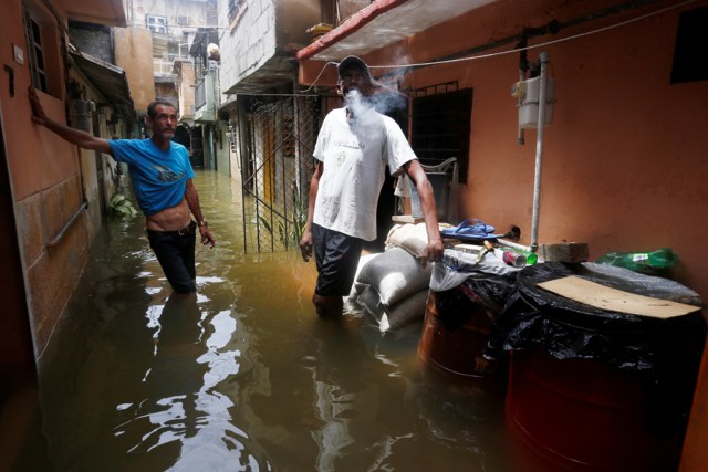 Men stand in the flooded passage of a block of flats after the passing of Hurricane Irma in Havana, Cuba, September 10, 2017. REUTERS/Stringer NO SALES. NO ARCHIVES