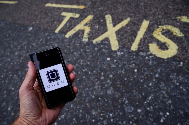 FILE PHOTO: A photo illustration shows the Uber app logo displayed on a mobile telephone, as it is held up for a posed photograph in central London, Britain October 28, 2016. This logo has been updated and is no longer in use. REUTERS/Toby Melville/Illustration/File Photo