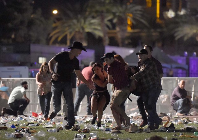 LAS VEGAS, NV - OCTOBER 01: (EDITORS NOTE: Image contains graphic content.) People carry a peson at the Route 91 Harvest country music festival after apparent gun fire was heard on October 1, 2017 in Las Vegas, Nevada. There are reports of an active shooter around the Mandalay Bay Resort and Casino.   David Becker/Getty Images/AFP