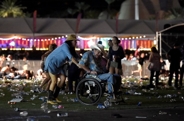 LAS VEGAS, NV - OCTOBER 01: A man in a wheelchair is taken away from the Route 91 Harvest country music festival after apparent gun fire was heard on October 1, 2017 in Las Vegas, Nevada. There are reports of an active shooter around the Mandalay Bay Resort and Casino.   David Becker/Getty Images/AFP