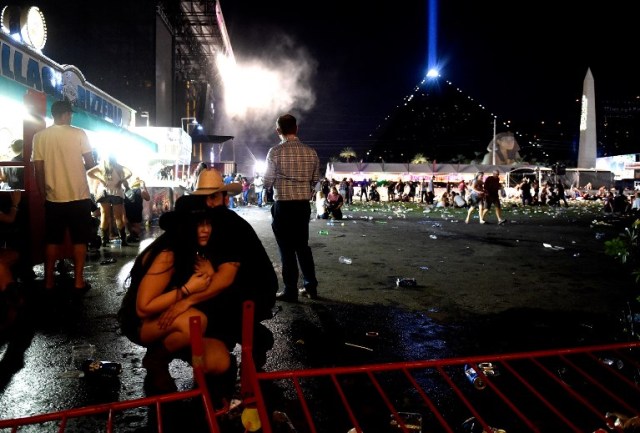 LAS VEGAS, NV - OCTOBER 01: People take cover at the Route 91 Harvest country music festival after apparent gun fire was heard on October 1, 2017 in Las Vegas, Nevada. There are reports of an active shooter around the Mandalay Bay Resort and Casino.   David Becker/Getty Images/AFP