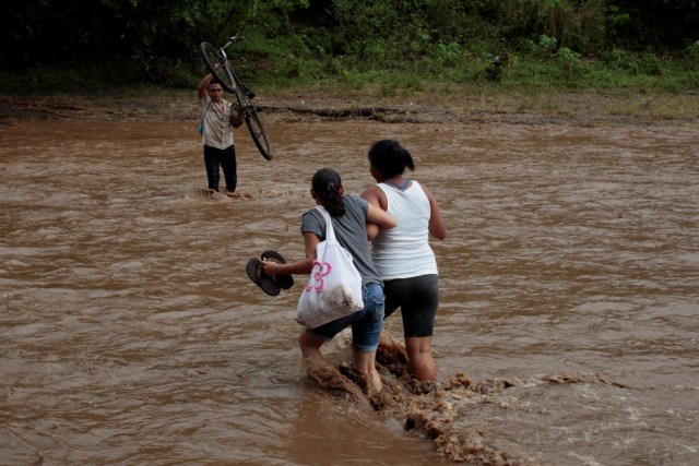 Local residents cross a river flooded by heavy rains by Tropical Storm Nate in Nandaime town, Nicaragua October 6, 2017. REUTERS/Oswaldo Rivas