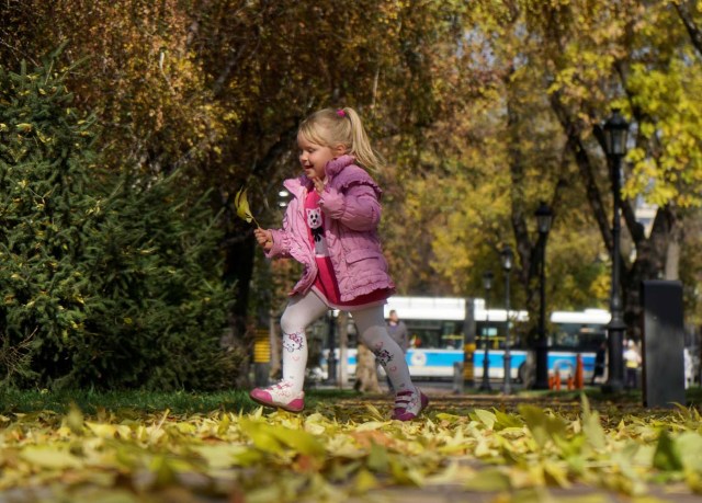 A girl runs in a park on a sunny autumn day in Almaty, Kazakhstan October 13, 2017. REUTERS/Shamil Zhumatov
