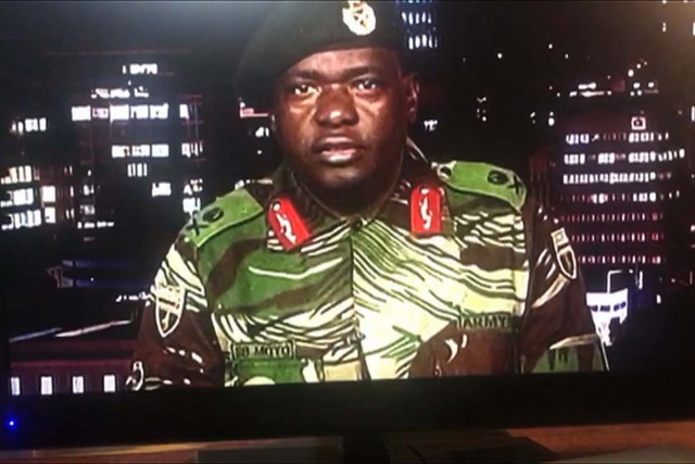 This screen grab taken early on November 15, 2017 from a television broadcast on the Zimbabwe Broadcasting corporation (ZBC) shows Zimbabwe Major General Sibusiso Moyo reading a statement at the ZBC broadcast studio in Harare. Zimbabwe's military appeared to be in control of the country on November 15 as generals denied staging a coup but used state television to vow to target "criminals" close to President Robert Mugabe. / AFP PHOTO / -