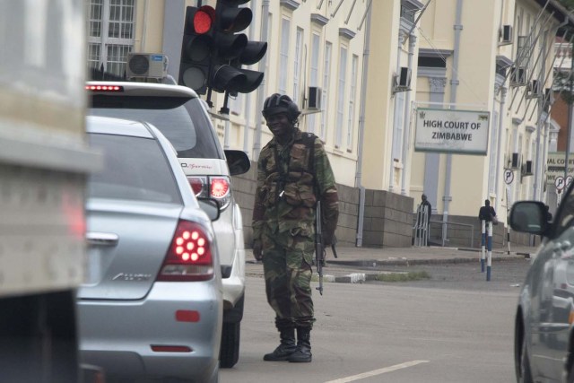 Zimbabwean soldiers stand by an intersection as they regulate civilian traffic in front of the High Court of Zimbabwe in Harare on November 15, 2017. Zimbabwe's military appeared to be in control of the country on November 15 as generals denied staging a coup but used state television to vow to target "criminals" close to President Mugabe. / AFP PHOTO / -