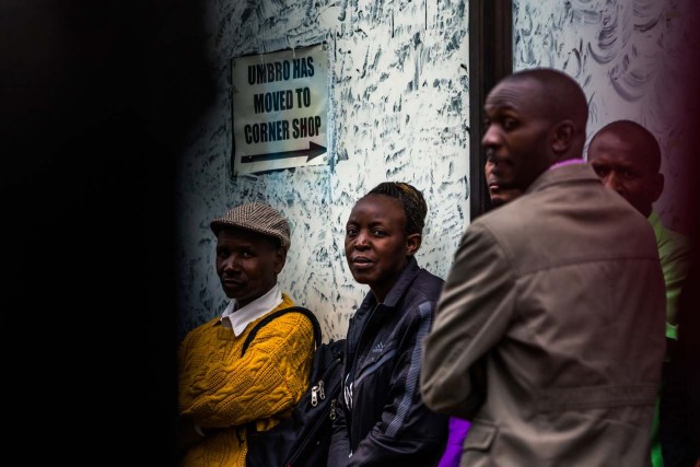 Harare residents look on as an armoured personnel carrier of the Zimbabwean military stands at an intersection in Harare on November 15, 2017. Zimbabwe's military appeared to be in control of the country on November 15 as generals denied staging a coup but used state television to vow to target "criminals" close to President Mugabe. / AFP PHOTO / -