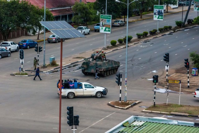 An armoured personnel carrier stations at an intersection as Zimbabwean soldiers regulate traffic in Harare on November 15, 2017. Zimbabwe's military appeared to be in control of the country on November 15 as generals denied staging a coup but used state television to vow to target "criminals" close to President Mugabe. / AFP PHOTO / -