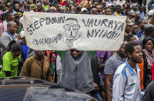 People carry placards during a demonstration demanding the resignation of Zimbabwe's president on November 18, 2017 in Harare. Zimbabwe was set for more political turmoil November 18 with protests planned as veterans of the independence war, activists and ruling party leaders called publicly for President Robert Mugabe to be forced from office. / AFP PHOTO / Jekesai NJIKIZANA