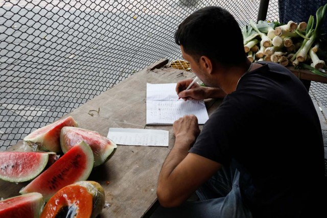 A vendor takes sales notes at a street market in Caracas, Venezuela November 3, 2017. Picture taken November 3, 2017. REUTERS/Marco Bello