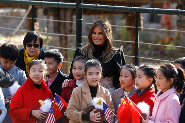 U.S. first lady Melania Trump smiles with children holding U.S. and China flags as she visits Beijing Zoo in Beijing, China, November 10, 2017. REUTERS/Thomas Peter