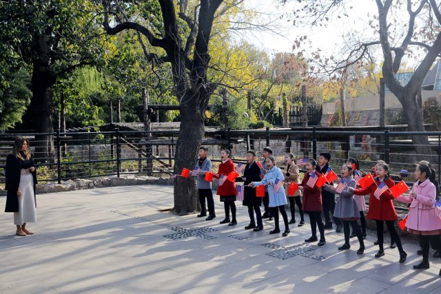 Children holding U.S. and China flags sing for U.S. first lady Melania Trump as she visits Beijing Zoo in Beijing, China, November 10, 2017. REUTERS/Thomas Peter