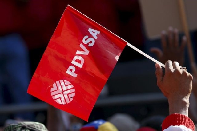 Un trabajador sostiene una bandera de PDVSA durante una reunión con el presidente de Venezuela, Nicolás Maduro en Caracas, ene 12, 2016. REUTERS/Carlos Garcia Rawlins