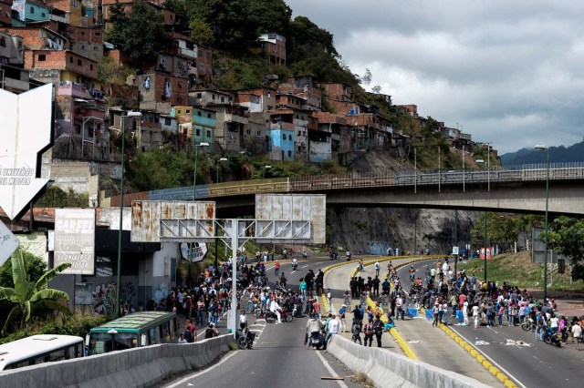 Venezuelans take part in a protest against the shortage of food in Caracas on December 28, 2017. As Venezuelans protest in Caracas demanding the government's prommised pork -the main dish of the Christmas and New Year's dinner-, President Nicolas Maduro attributes the shortage to international sabotage. / AFP PHOTO / FEDERICO PARRA