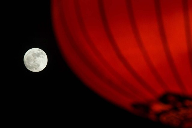 The supermoon is seen rising behind a red lantern in Beijing, China January 1, 2018. Picture taken January 1, 2018. REUTERS/Stringer ATTENTION EDITORS - THIS IMAGE WAS PROVIDED BY A THIRD PARTY. CHINA OUT.