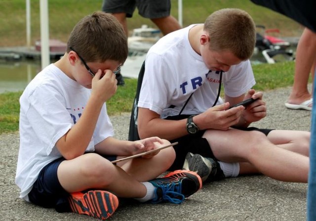 Niños juegan con un iPad y un iPhone antes de un acto político a favor de Donald Trump en Cincinnati. Imagen de archivo. 7 de junio de 2017. REUTERS/John Sommers II