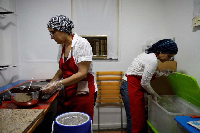 Adriana Pino (L) and Teresa Pino make chocolate bars at the +58 Cacao chocolate factory in Caracas, Venezuela October 6, 2017. Picture taken October 6, 2017. REUTERS/Carlos Garcia Rawlins