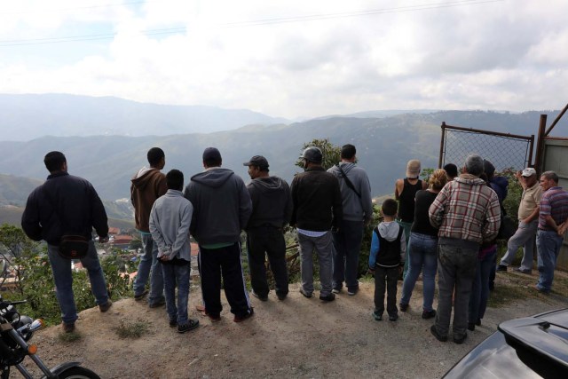 People look during a shootout between security forces and rogue Venezuelan helicopter pilot Oscar Perez, in Caracas, Venezuela January 15, 2018. REUTERS/Marco Bello