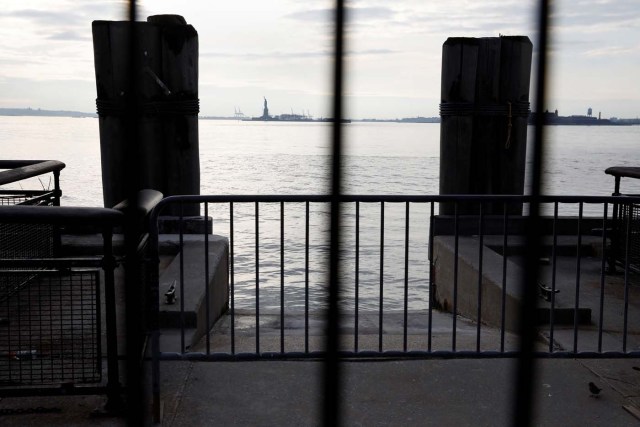 The Statue of Liberty is seen through fencing from a ferry dock following a U.S. government shutdown in Manhattan, New York, U.S., January 21, 2018. REUTERS/Shannon Stapleton