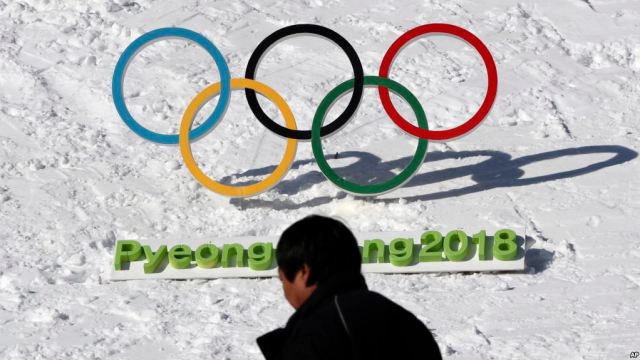 HOLD FOR USE WITH STORY SLUGGED SOUTH KOREA OLYMPICS TICKETS BY KIM TONG-HYUNG, In this Feb. 3, 2017 photo, a man walks by the Olympic rings with a sign of 2018 Pyeongchang Olympic and Paralympic Winter Games in Pyeongchang, South Korea. (AP Photo/Lee Jin-man)