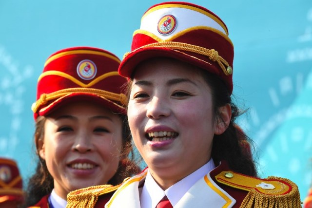 North Korean cheerleaders smile as they prepare to perform before a welcoming ceremony for North Korea's Olympic team at the Olympic Village in Gangneung on February 8, 2018 ahead of the Pyeongchang 2018 Winter Olympic Games. / AFP PHOTO / JUNG Yeon-Je