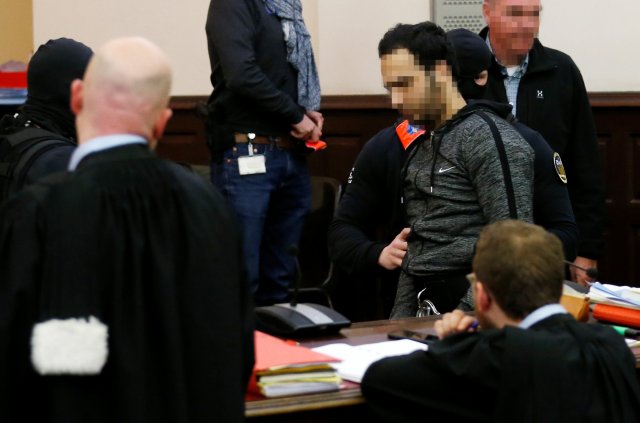 Sofien Ayari es escoltado por policías belgas cuando llega a la sala del tribunal el segundo día del juicio de Salah Abdeslam y Ayari en el Palacio de Justicia de Bruselas, Bélgica, el 8 de febrero de 2018. REUTERS / Francois Lenoir EDITORES DE ATENCIÓN - LA CARA DEL DEMANDADO TIENE SIDO PIXELADO POR ORDEN JUDICIAL.