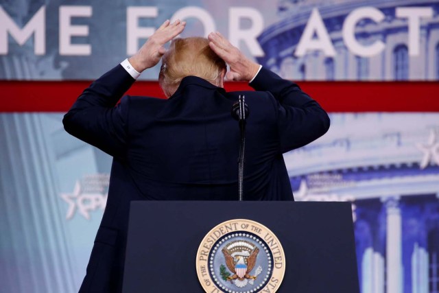 U.S. President Donald Trump pretends to smooth his hair as he speaks at the Conservative Political Action Conference (CPAC) at National Harbor, Maryland, U.S., February 23, 2018. REUTERS/Joshua Roberts