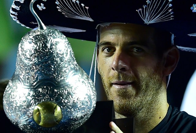 Argentina's Juan Martin del Potro wears a traditional Mexican mariachi hat while holding the winning trophy after defeating Kevin Anderson of South Africa at the Mexico ATP Open men's single final in Acapulco, Guerrero state on March 3, 2018. / AFP PHOTO / PEDRO PARDO