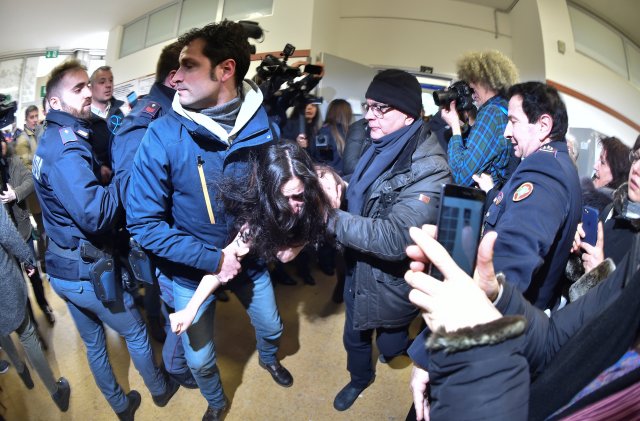 La policía italiana bloquea a un activista del grupo de derechos femeninos Femen en la mesa de votación donde el líder del partido Forza Italia, Silvio Berlusconi, emitió su voto en Milán, Italia, el 4 de marzo de 2018. Fotografía tomada con una lente ojo de pez. REUTERS / Alberto Lingria