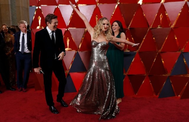 90th Academy Awards - Oscars Arrivals - Hollywood, California, U.S., 04/03/2018 - Jennifer Lawrence poses as Jason Blum (L) and Lauren Schuker (R) look on. REUTERS/Carlo Allegri