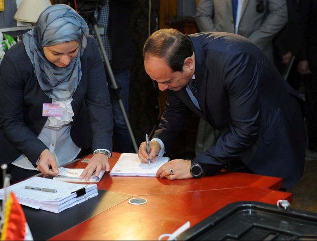 Egyptian President Abdel Fattah al-Sisi writes as he arrives to cast his vote during the presidential election in Cairo, Egypt, March 26, 2018. The Egyptian Presidency/Handout via REUTERS ATTENTION EDITORS - THIS IMAGE WAS PROVIDED BY A THIRD PARTY.